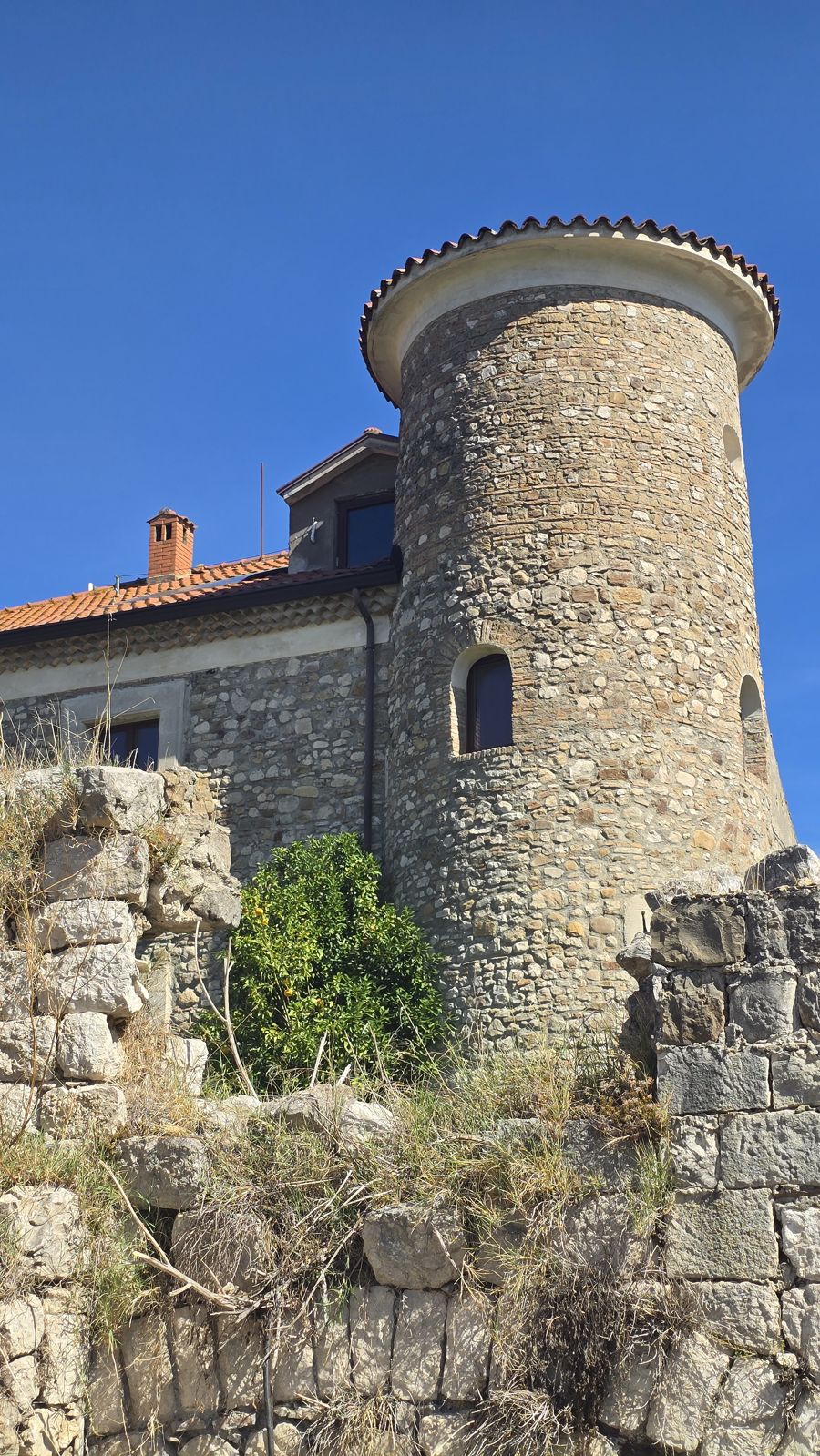 La torre vista oltre un antico muro in pietra